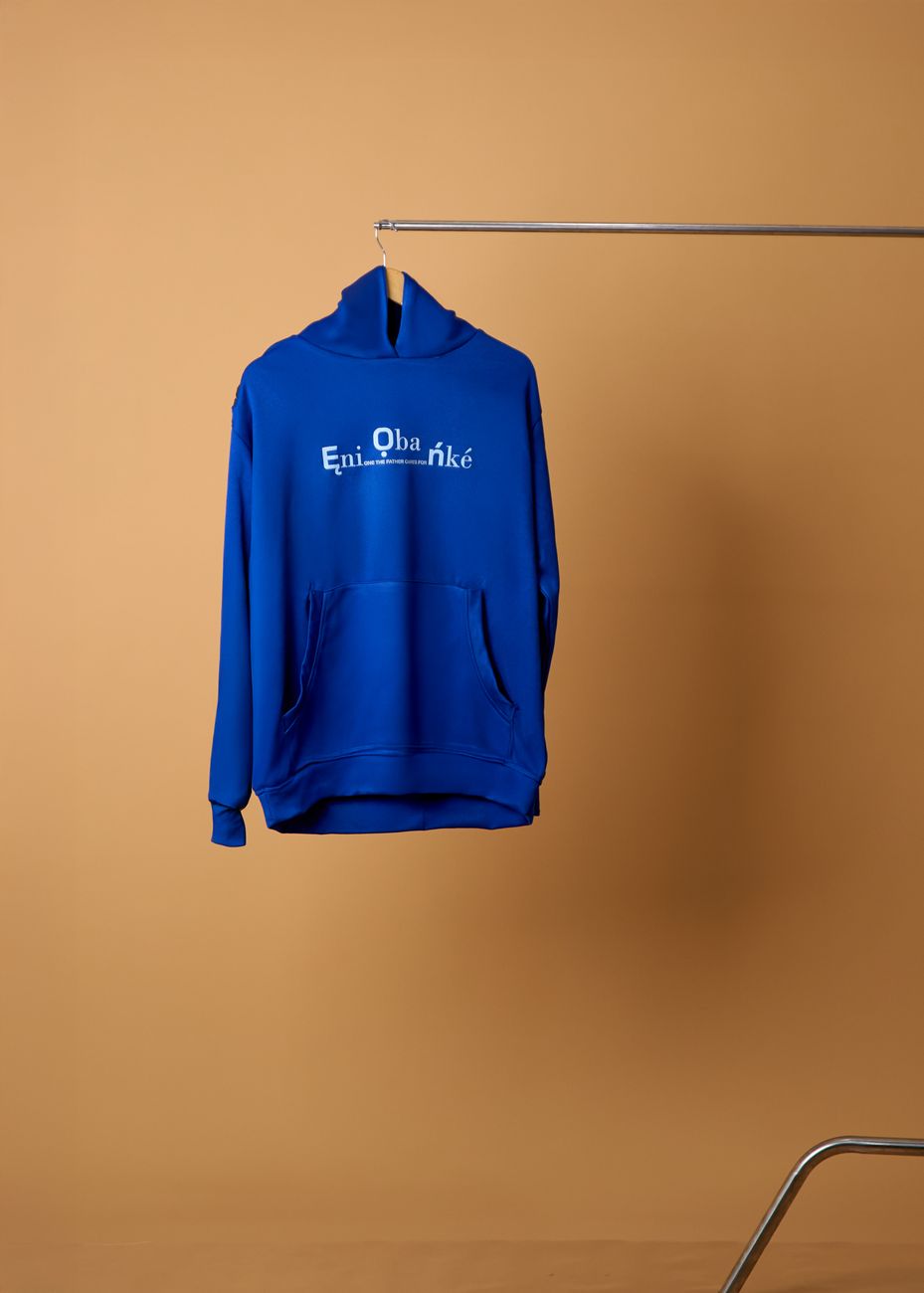 Buzo azul con capucha exhibido sobre fondo minimalista